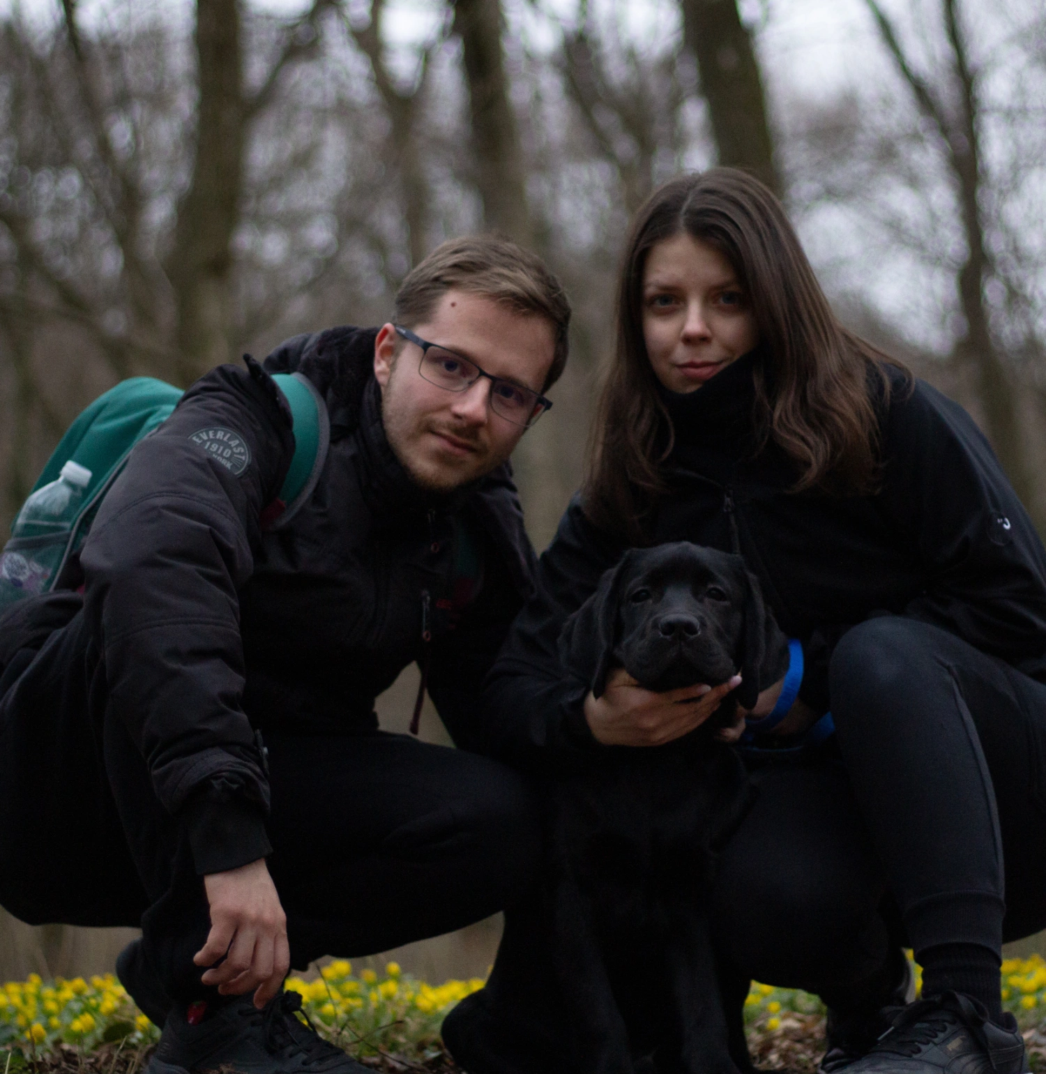 Gazdi a fekete kutyájával piros Ebklikk HEXA pórázon és harnesszel